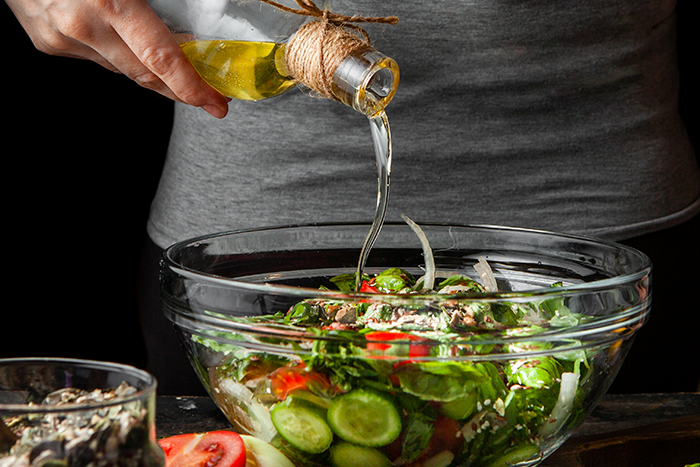 pouring oil on salad