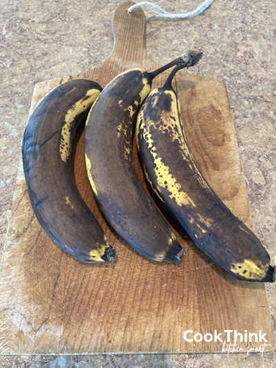 very ripe bananas on a wood cutting board